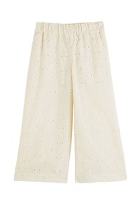 Culottes en coton beige clair avec une taille élastique, présentant des motifs floraux et de petits trous en œillet dans tout le tissu.