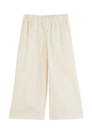 Culottes en coton beige clair avec une taille élastique, présentant des motifs floraux et de petits trous en œillet dans tout le tissu.