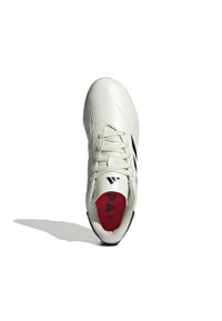 Zapatilla deportiva blanca con parte superior texturizada, acentos negros y plantilla interior roja. Presenta cordones y un diseño aerodinámico para el rendimiento.