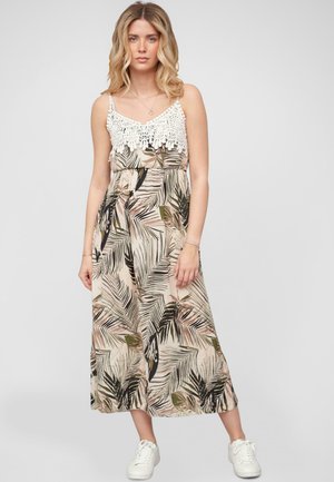 Robe maxi avec un haut en dentelle crochet et des bretelles ajustables, présentant un fond beige avec des motifs de feuilles tropicales vertes et noires.