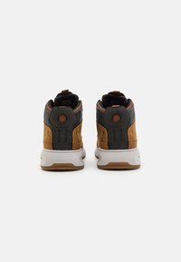 Wysokie sneakersy wykonane z materiałów skórzanych i syntetycznych. Brązowy i szary schemat kolorystyczny, masywna biała podeszwa oraz okrągłe akcenty na pięcie.