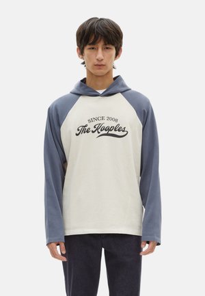 Bluza z kapturem o kremowym korpusie i niebieskimi rękawami raglanowymi. Z przodu nadrukowane "Since 2008 The Kooples". Wykonana z miękkiej tkaniny bawełnianej.