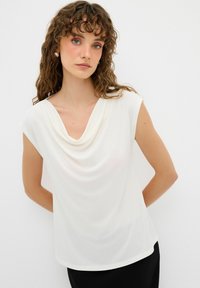Weiße, drapierte Bluse mit einem Cowl-Halsausschnitt und kurzen Ärmeln, aus leichtem Stoff gefertigt. Glatte Textur mit lockerer Passform.