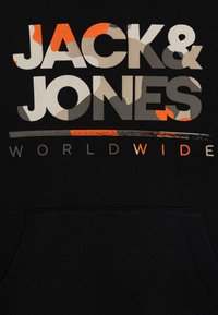 Čierna mikina s kapucňou s nápisom "JACK & JONES" v šedej, oranžovej a béžovej kamuflážovej potlači, s nápisom "WORLDWIDE" bielou farbou nižšie. Mäkká textúra, dizajn s kapucňou.