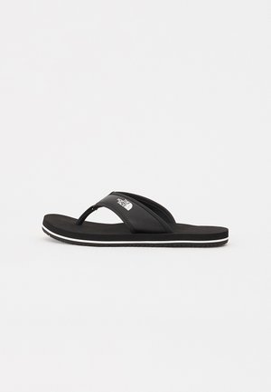 Sort flip-flop sandal med en struktureret strop og hvid accent. Flad sål med en gummibelægning for godt greb og komfort.