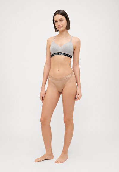 Gray bralette with black logo band and thin straps, paired with nude-colored thong with subtle branding at the waistband. Simple, modern design.