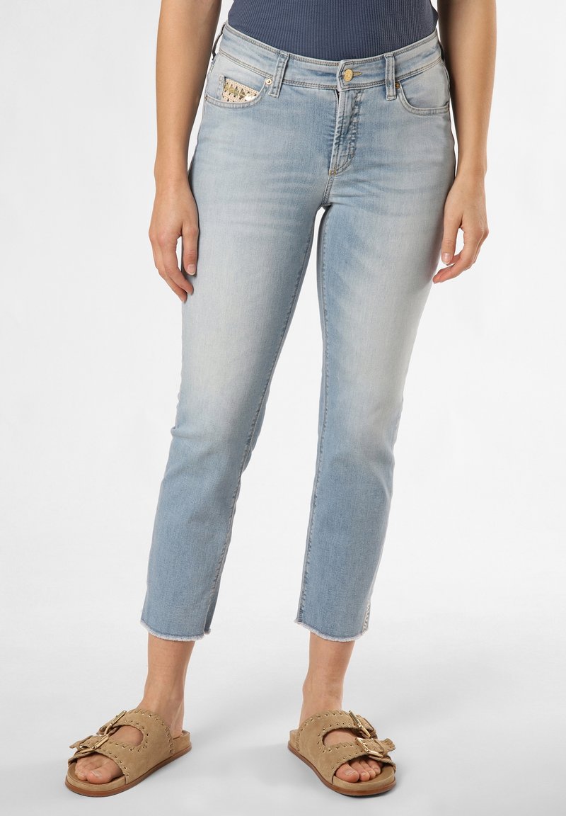 Ljusblå denimjeans med slim fit, avslutad längd och fransade fållar. Har dekorativa detaljer på fickorna. Matchas med tanfärgade slidesandaler.