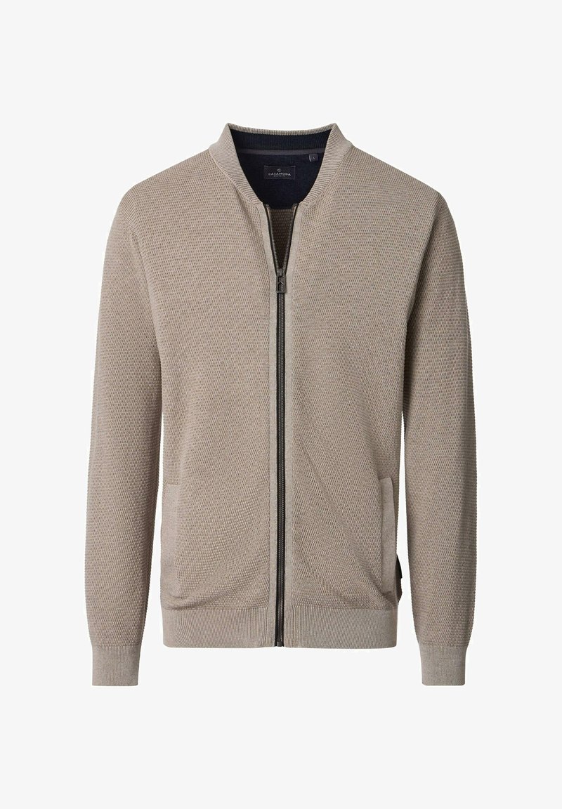 Beige Jacke mit Reißverschluss und strukturiertem Strickmuster. Mit rundem Kragen, zwei Vorderentaschen und gerippten Bündchen.