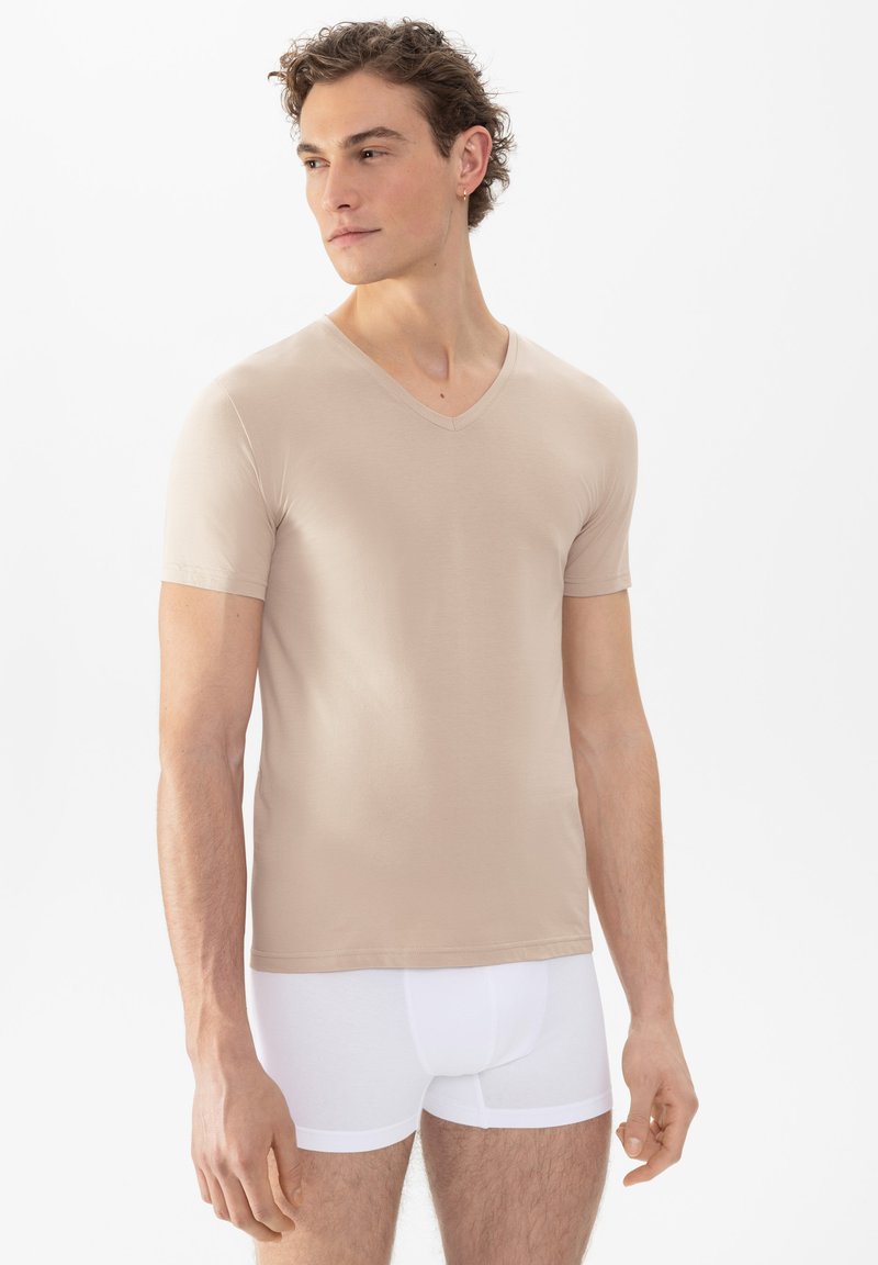 Beige V-hals t-shirt gemaakt van een gladde, lichte stof, met korte mouwen en een getailleerd ontwerp, gecombineerd met witte boxershorts.