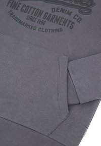 Graue Baumwoll-Hoodie mit einer Fronttasche, gerippten Bündchen und einem grafischen Druck, der "Feine Baumwollbekleidung" in dunkelgrün sagt.