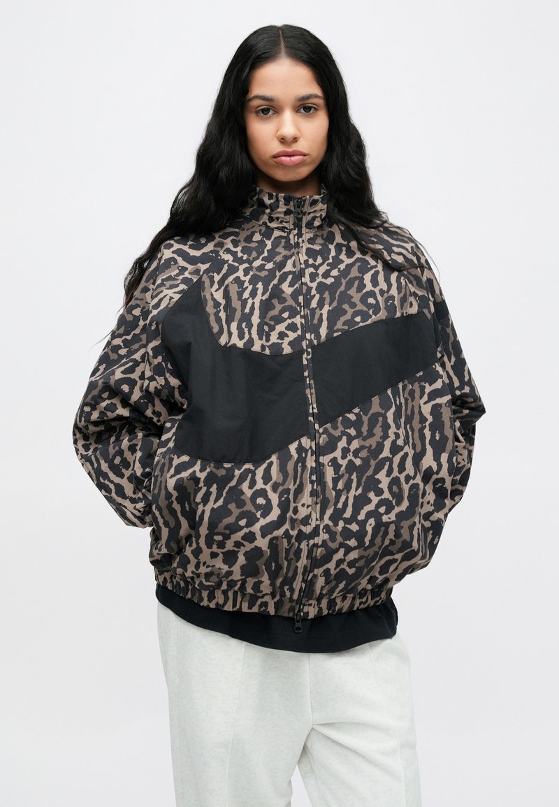 Bomberjack met dierenprint in bruintinten en zwart, voorzien van een effen zwart paneel over de borst, ritssluiting en elastische zoom.