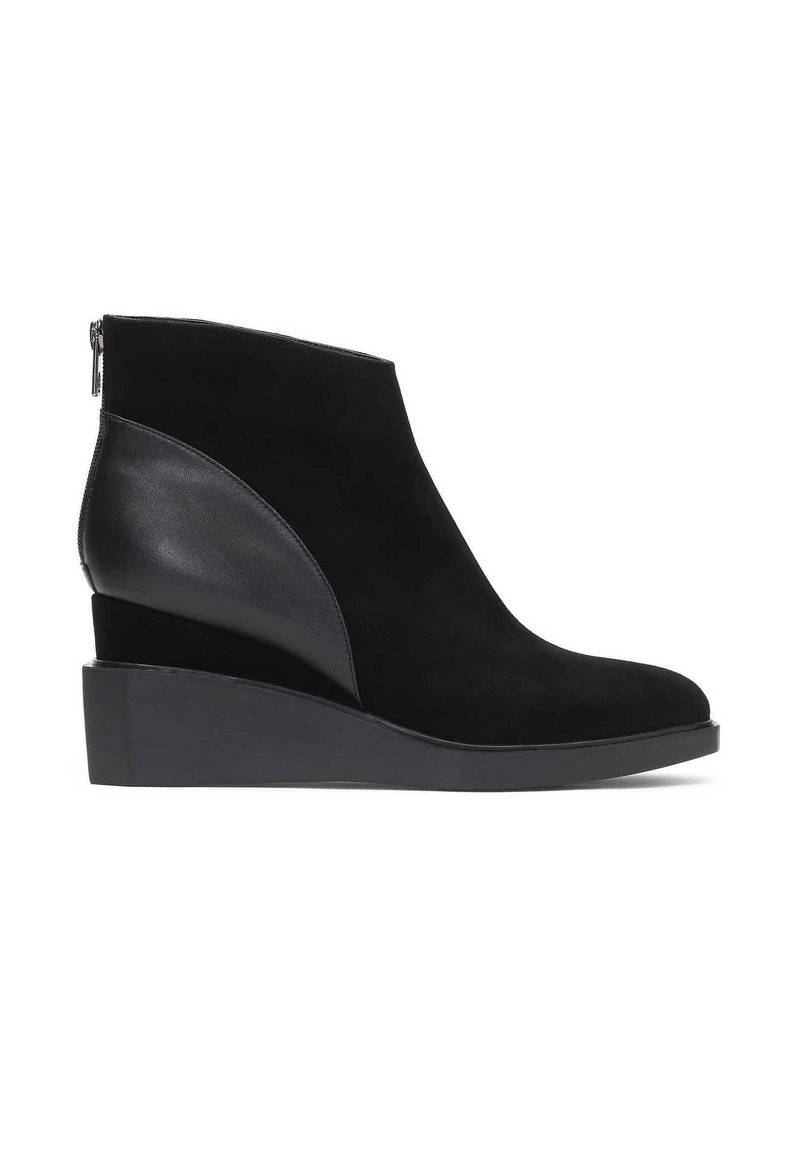 Stivaletti alla caviglia in suede nero con tacco a zeppa, cerniera laterale e pannello in pelle a contrasto sul lato esterno. Texture della superficie liscia.