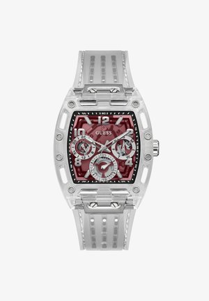 Reloj con caja transparente y esfera marrón. Presenta índices horarios blancos, tres subesferas y una correa de silicona transparente con estrías verticales.