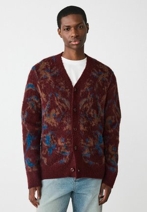 Burgundy knitted cardigan featuring a textured pattern with brown and blue accents, five buttons, and a v-neck design.