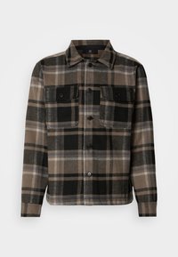 Brown and black plaid shirt made of soft fabric, featuring a button-up front, two chest pockets, and a classic collar design.