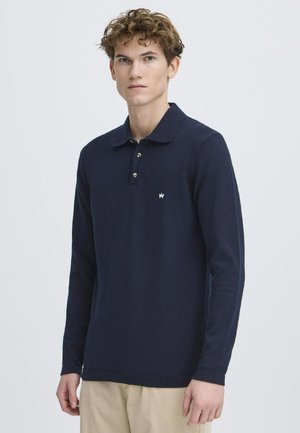 Polo majica dugih rukava u mornarsko plavoj boji, pleteni materijal, placket s tri gumba, mali logo na prsima, rebrasti manžeti i rub.
