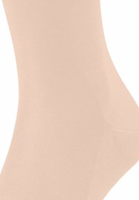 Calzini alla caviglia beige, realizzati in materiale morbido e elasticizzato con una texture a coste. Presentano una forma sagomata per una vestibilità e un comfort ottimali.