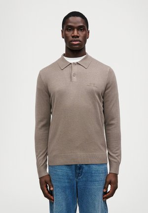 Braunes Langarm-Polohemd mit Kragen, aus strukturiertem Stoff und dezentem Logo auf der Brust, kombiniert mit blauen Jeans.