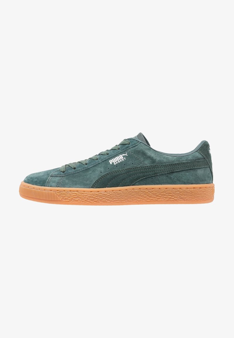 Baskets basses Puma Basket en daim vert foncé avec semelle en gomme et logo Puma blanc sur le côté.