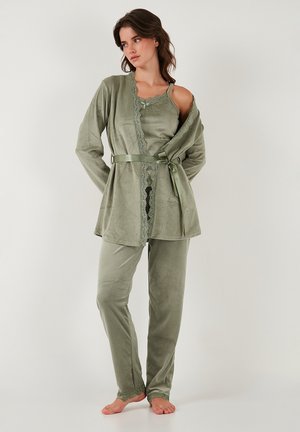 Grønt loungewear-sæt i blødt, tekstureret stof. Toppen har blondekant langs udskæringen og en bundet talje, med matchende bukser.