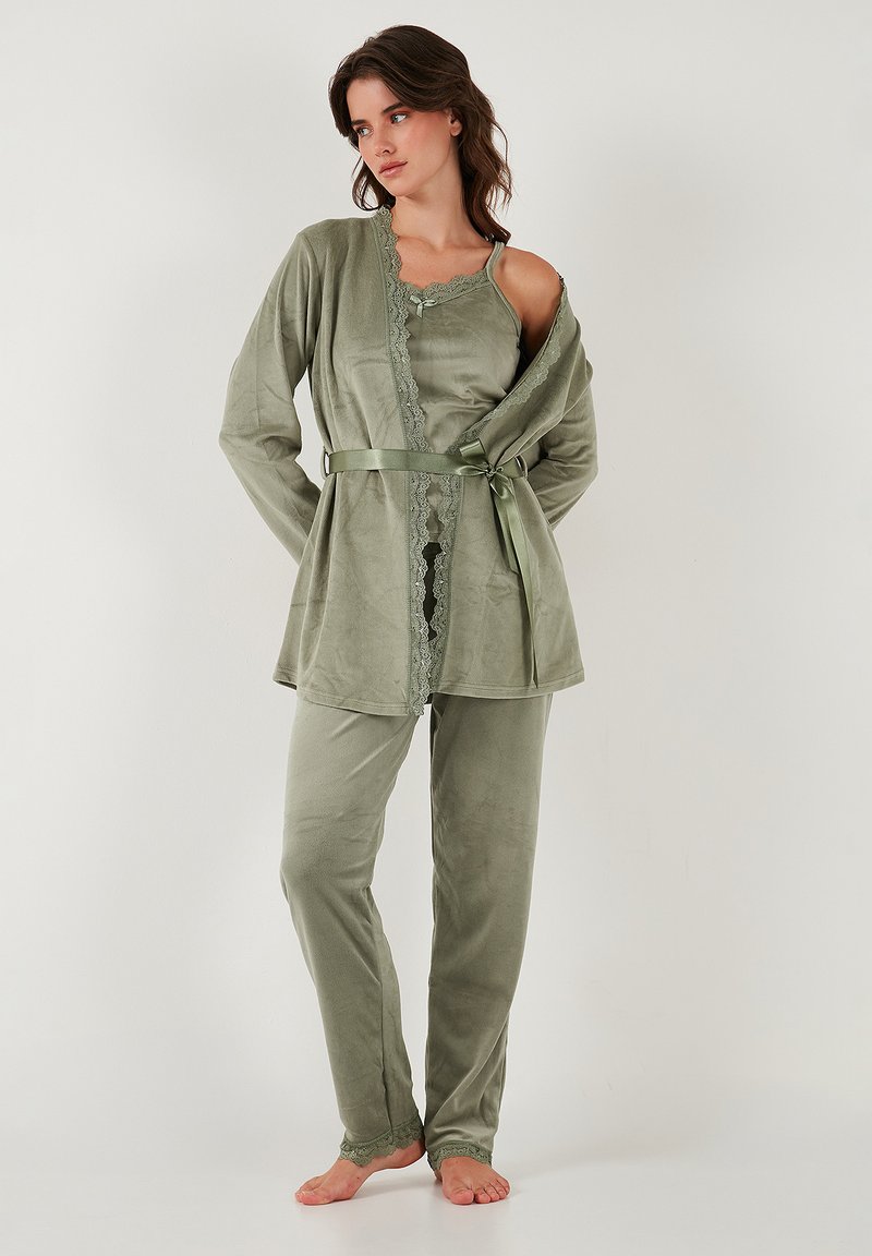 Groene loungewear-set van een zachte, gestructureerde stof. De top heeft kant langs de halslijn en een strikceintuur, met bijpassende broek.