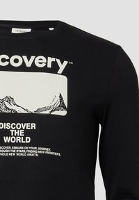 Schwarzes Langarm-T-Shirt mit einem weißen Grafikdesign, das Berge zeigt und den Text: "ENTDECKE DIE WELT" in fetter Schrift darunter.