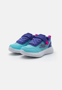 Türkisfarbene und lila sportive Schuhe mit einem Obermaterial aus Mesh, Gummisohle und verstellbarem Riemen mit pinkem Akzent. Entwickelt für Komfort und Unterstützung.