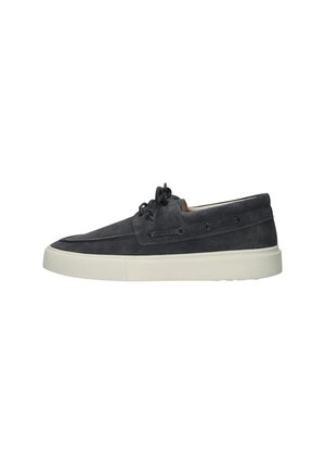 Chaussure casual en daim gris foncé à lacets, semelle épaisse en caoutchouc blanc, coupe basse autour de la cheville, détail de laçage latéral et bout arrondi.