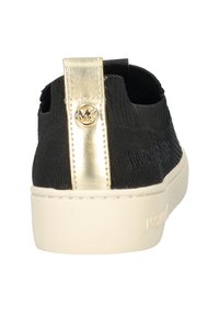 Sneaker nera con tomaia in tessuto testurizzato, linguetta metallica dorata con logo e suola in gomma bianca.