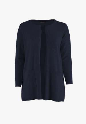 Laivastonsininen avoimella edustalla oleva neulejakku, jossa on pitkät hihat ja kaksi etutaskua, valmistettu pehmeästä neuloksesta.