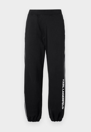 Mustad spordihädas püksid elastse vöökoha ja varrukatega, valgete külgtriipudega ning "KARL LAGERFELD" logoga vasakul jalal. Pehme kangastekstuur.