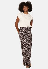 Cream short-sleeve top paired with pink and black zebra-striped wide-leg pants, featuring a relaxed fit and a flat waistband.