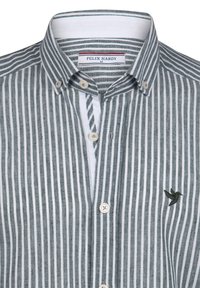 Camisa a rayas gris y blanca con cuello abotonado, que presenta un pequeño logo de ave bordado y cierres de botón blancos en la parte delantera.