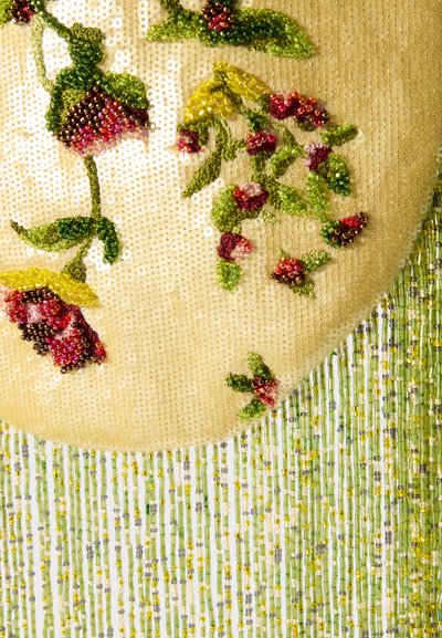 Haft koralikowy z kwiatami w czerwonych odcieniach oraz zielonymi liśćmi na jasnym tle, z wiszącymi pasmami żółtych, zielonych i przezroczystych koralików.