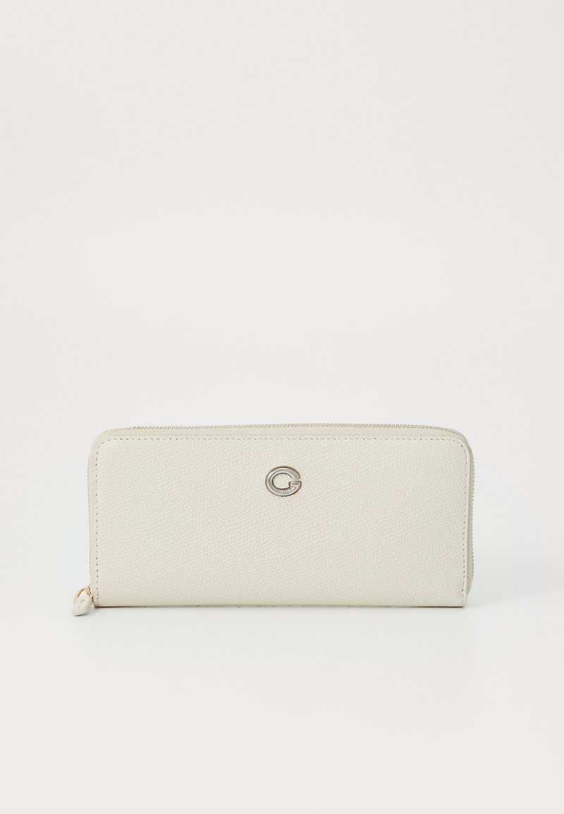 Portefeuille texturé blanc avec une fermeture éclair lisse, arborant un logo "G" en relief argenté à l'avant. Forme compacte et rectangulaire.