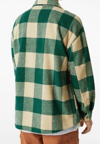 Grün-beige karierter Flanellhemd mit einer weichen Textur, ausgestattet mit einem Kragen, langen Ärmeln und einem lässigen Schnitt.