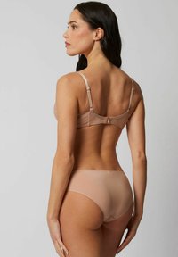 Kanten en satijnen bh in nude met verstelbare banden en een haaksluiting, gecombineerd met gladde, naadloze nude slipjes.