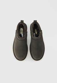 Σκούρα γκρι μπότες από σουέντ με εύκολη εφαρμογή, μαλακή, αφράτη επένδυση και στρογγυλή μύτη. Διαθέτουν χαμηλό προφίλ και ελάχιστες ραφές ως διακοσμητικά στοιχεία.