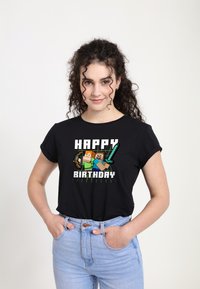 Černé tričko s grafickým designem a textem "ŠŤASTNÉ NAROZENINY" a pixelovanými postavami, které drží nářadí. Měkká tkanina, pohodlný střih.