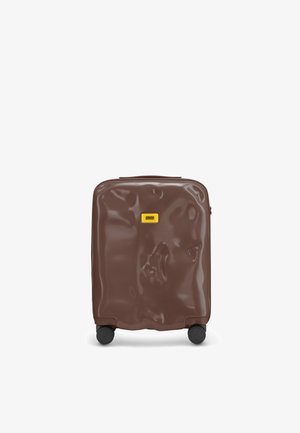 Valigia rigida marrone con una superficie lucida e testurizzata, dotata di un logo del marchio giallo, doppie ruote nere e chiusura con zip.