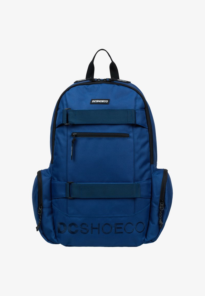 Blue fabric backpack with two front zip pockets, adjustable straps, and logo detail. Features a top carry handle and side compartment.
