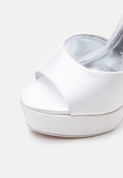 Λευκό πέδιλο πλατφόρμα με ανοιχτό δάχτυλο και φαρδύ λουρί, με ασημένια μεταλλική εσωτερική σόλα και λεία επιφάνεια.