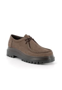 Scarpa in suede marrone con punta arrotondata, dettagli di cucitura in rilievo e una spessa suola in gomma nera caratterizzata da profonde scanalature per una migliore aderenza.