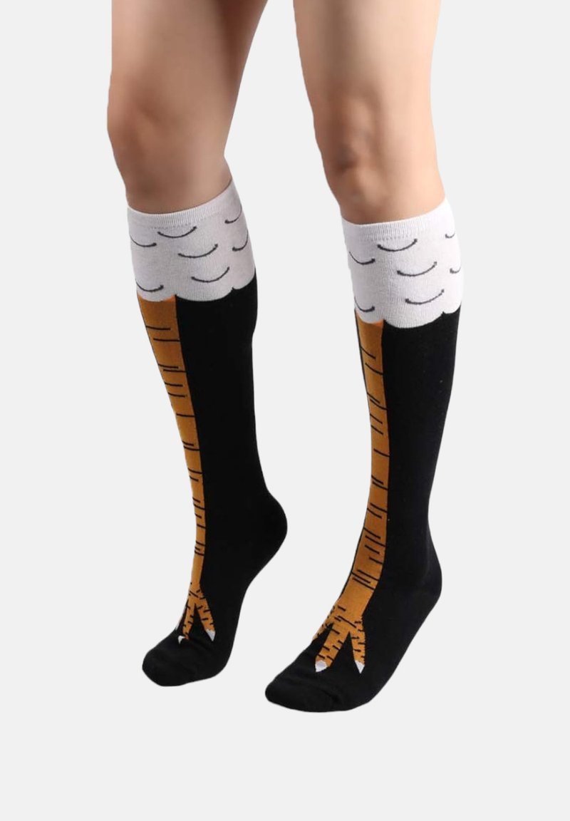 Calcetines de altura hasta la rodilla con una base negra, diseño de rayas en tonos marrones que recuerda a patas de animales, con un patrón de nubes blancas en la parte superior y detalles en la punta. 