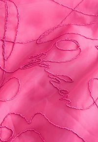 Rosa durchsichtige Stoffe mit komplizierter pinkfarbener Stickerei, die fließende Linien bildet und "Wander" spell.