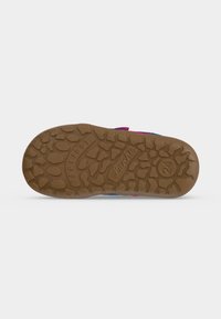 Semelle en caoutchouc marron texturée d'une chaussure d'enfant montrant le motif d'adhérence et la taille 24 sur fond blanc.