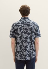 Kurzarmhemd in Marineblau mit einem hellgrauen Palmenmuster, mit Kragen, lässiger Schnitt, aus leichtem Stoff.