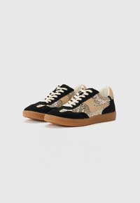 Basket de sport en suède noir avec des accents en paillettes dorées, présentant une bande latérale beige, une languette beige et des lacets crème sur une semelle en gomme.