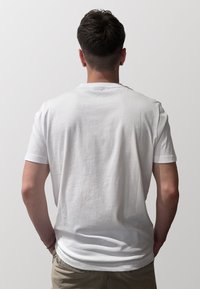 T-shirt bianco in cotone con maniche corte e scollo rotondo classico, caratterizzato da una texture liscia e una vestibilità comoda.