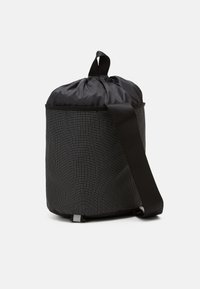 Round black bag with a smooth drawstring top, grid pattern on the body, and a detachable strap. Made from durable fabric, easy to carry.